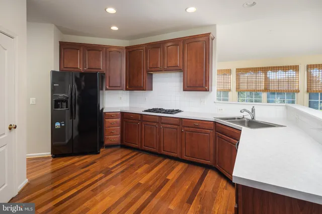 a kitchen with stainless steel appliances granite countertop a refrigerator and a sink