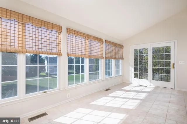 a view of front door with wooden floor and windows