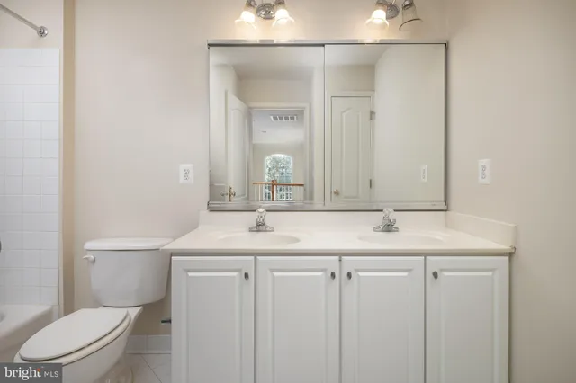 a bathroom with a granite countertop sink a toilet and a mirror