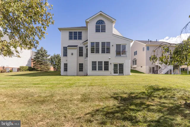 a view of a big house with a yard and large trees