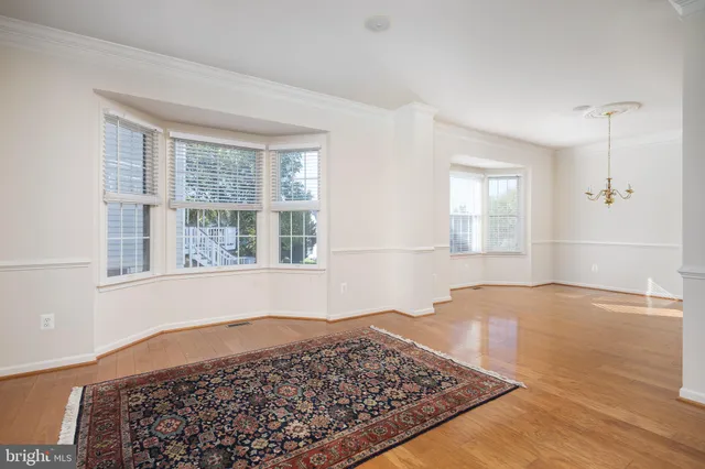 a view of a bedroom with wooden floor and a window