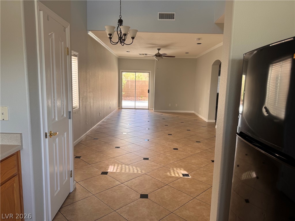 8937 Austin Ridge Avenue Las Vegas, NV 89178 - Photo 16 of 22 Natural light floods this living area through sliding glass doors, illuminating the elegant tile flooring and crown molding.