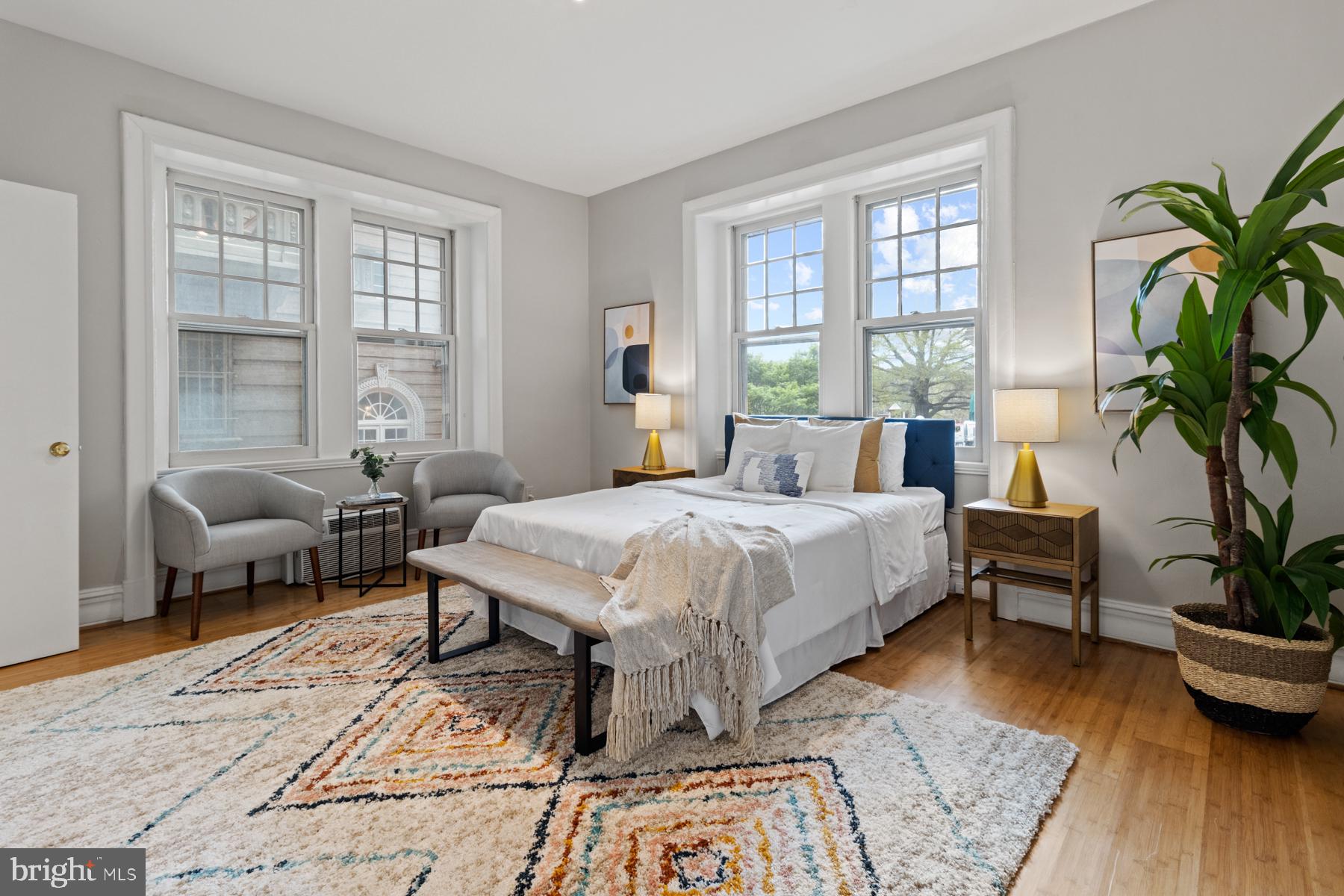 3420 16th Street Northwest, Unit 101 Washington, DC 20010 - Photo 16 of 29 a spacious bedroom with a bed a table and a potted plant
