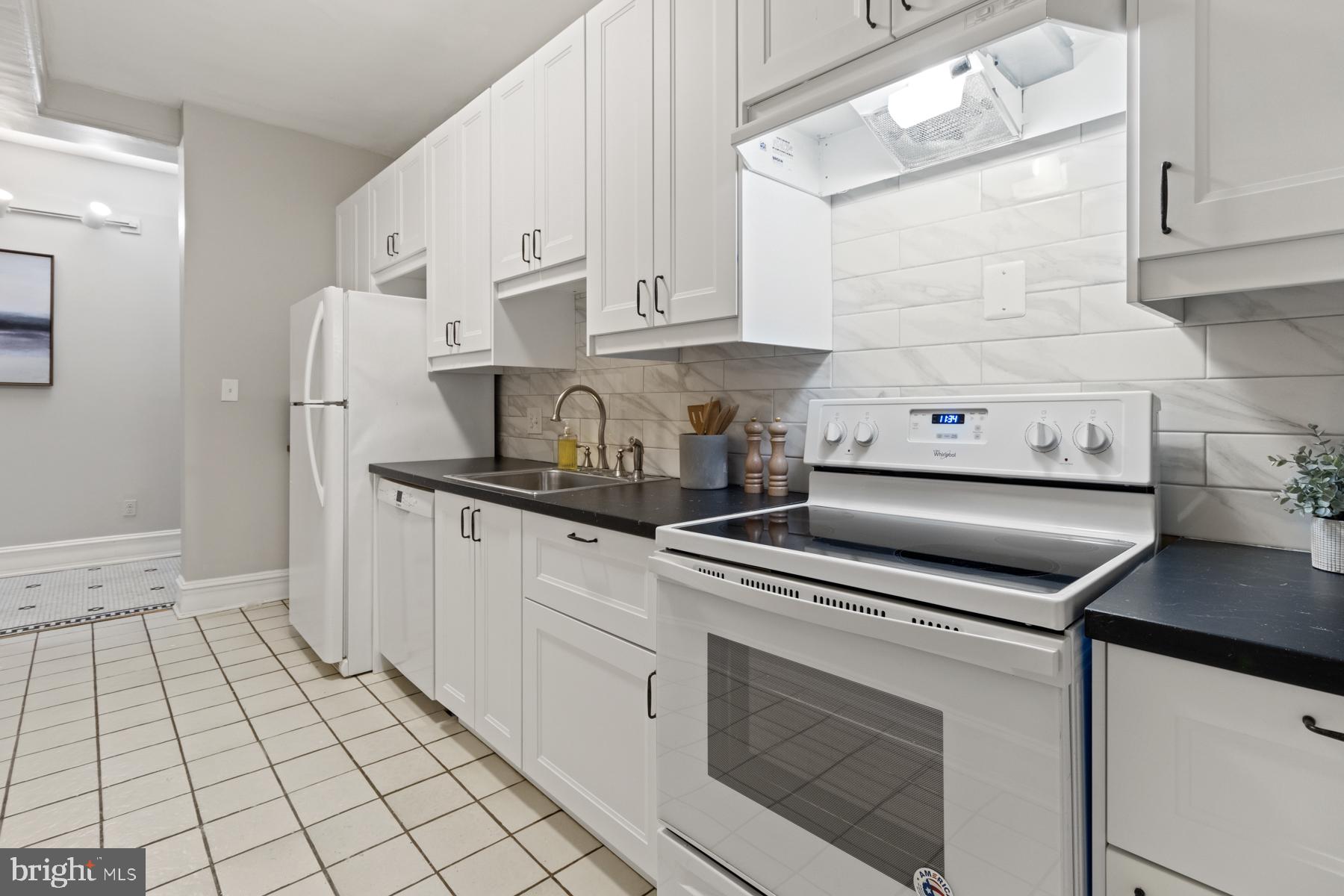 3420 16th Street Northwest, Unit 101 Washington, DC 20010 - Photo 4 of 29 a kitchen with white cabinets and appliances
