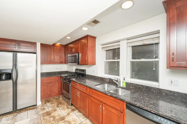 a kitchen with stainless steel appliances granite countertop a sink stove and refrigerator