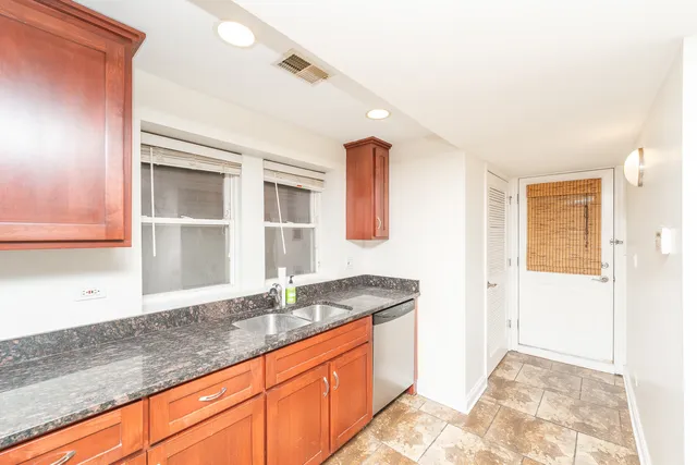 a bathroom with a granite countertop sink and a mirror