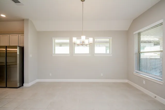 a dining room with furniture a chandelier and window