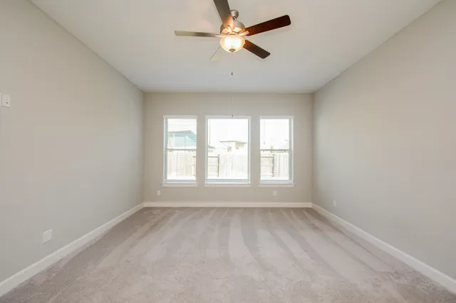 a view of a room with a ceiling fan and a window