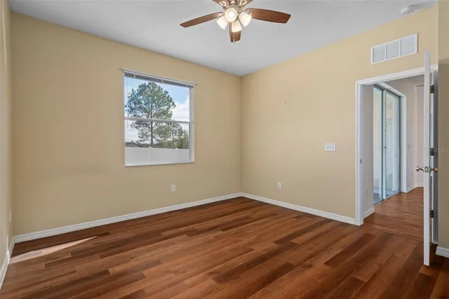 a view of empty room with wooden floor