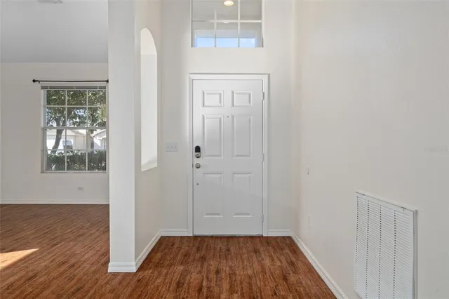a view of a hallway with wooden floor and a cabinet