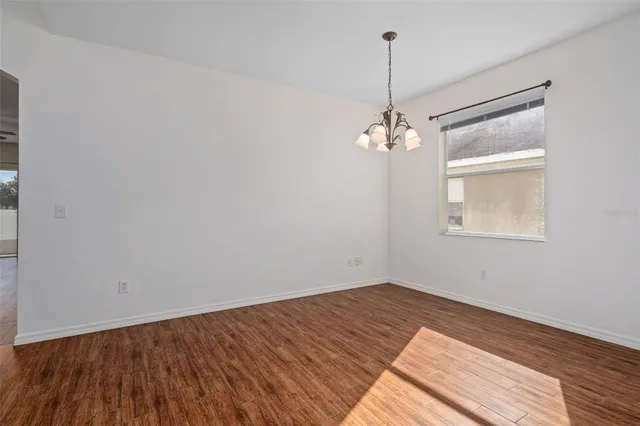 a view of a room with wooden floor and white walls