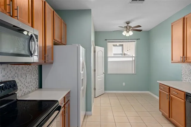 a kitchen with stainless steel appliances granite countertop a refrigerator and a stove top oven