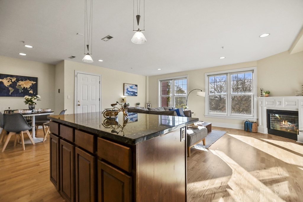1306 Columbia Road, Unit 3E Boston, MA 02127 - Photo 12 of 40 a dining hall with stainless steel appliances granite countertop a stove top oven a dining table and chairs with wooden floor