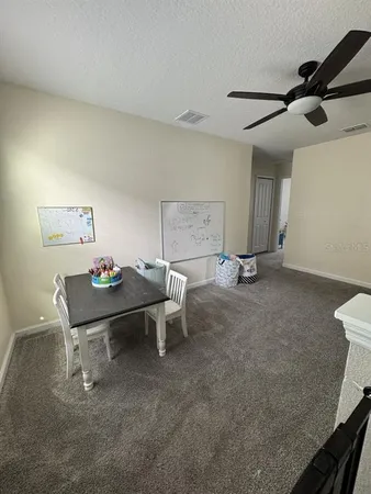 a living room with furniture and a air conditioner vent