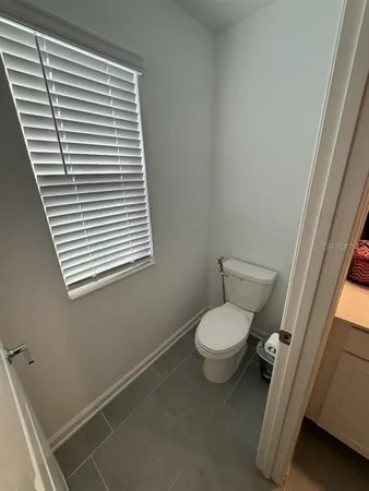 a bathroom with a toilet and a window