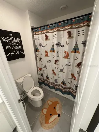 a bathroom with a toilet and a shower curtain