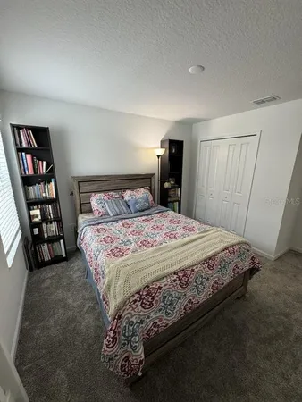 a bedroom with a bed and a book shelf