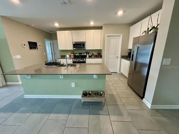 a kitchen with stainless steel appliances granite countertop a refrigerator and a sink