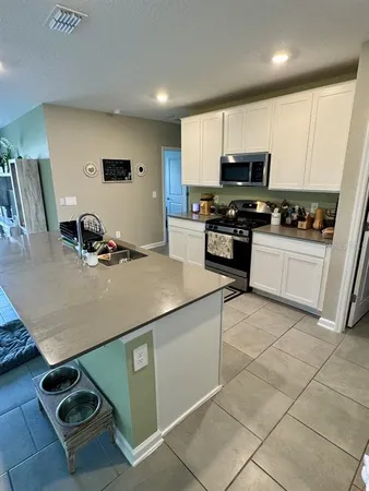 a kitchen with kitchen island white cabinets and appliances