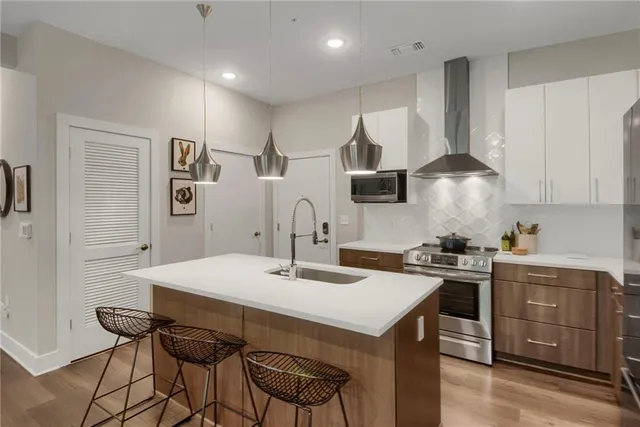 a kitchen with stainless steel appliances a sink a stove a refrigerator and cabinets