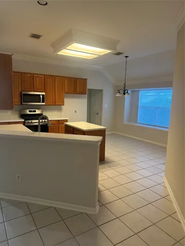 a kitchen with stainless steel appliances a sink a stove a microwave a sink a refrigerator and cabinets