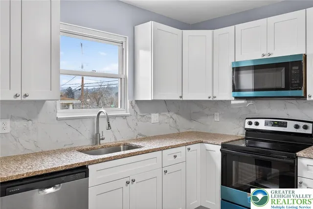 a kitchen with appliances a sink and cabinets