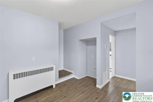 a view of an empty room with wooden floor