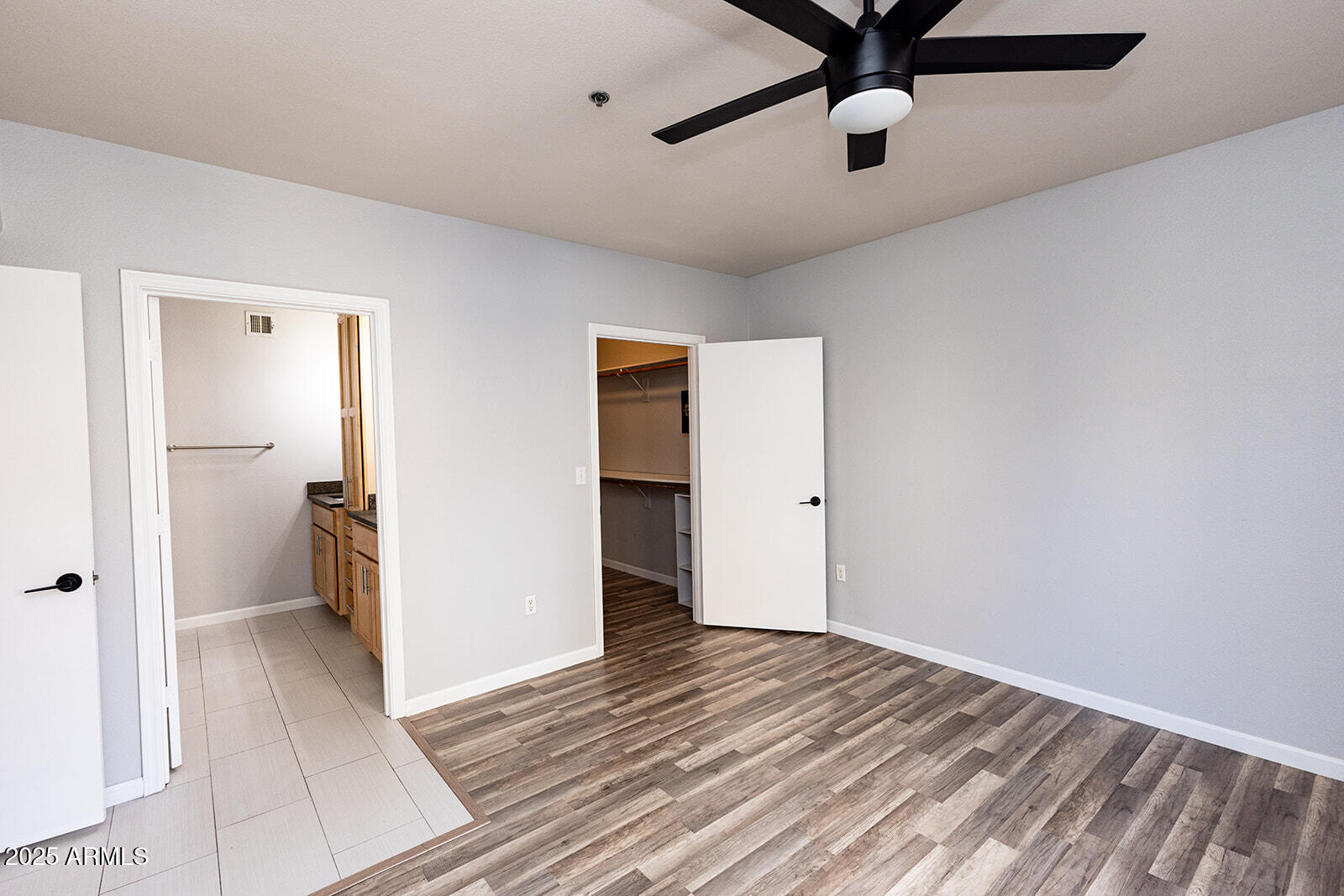 2134 East Broadway Road, Unit 1016 Tempe, AZ 85282 - Photo 21 of 33 a view of a room with wooden floor and a ceiling fan