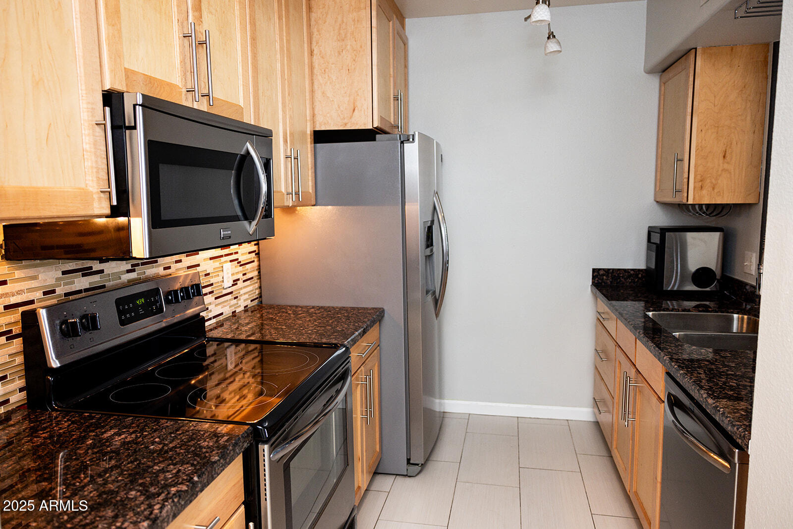 2134 East Broadway Road, Unit 1016 Tempe, AZ 85282 - Photo 6 of 33 a kitchen with stainless steel appliances granite countertop a stove and a microwave