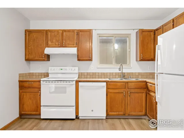 a kitchen with a stove a refrigerator and a sink