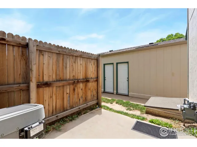 a view of a backyard with tub and wooden fence
