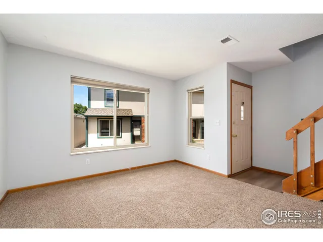 an empty room with windows and fireplace