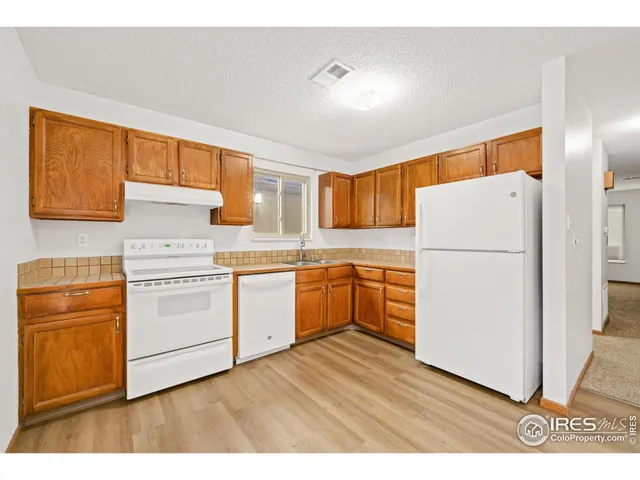 a kitchen with a refrigerator sink stove and cabinets