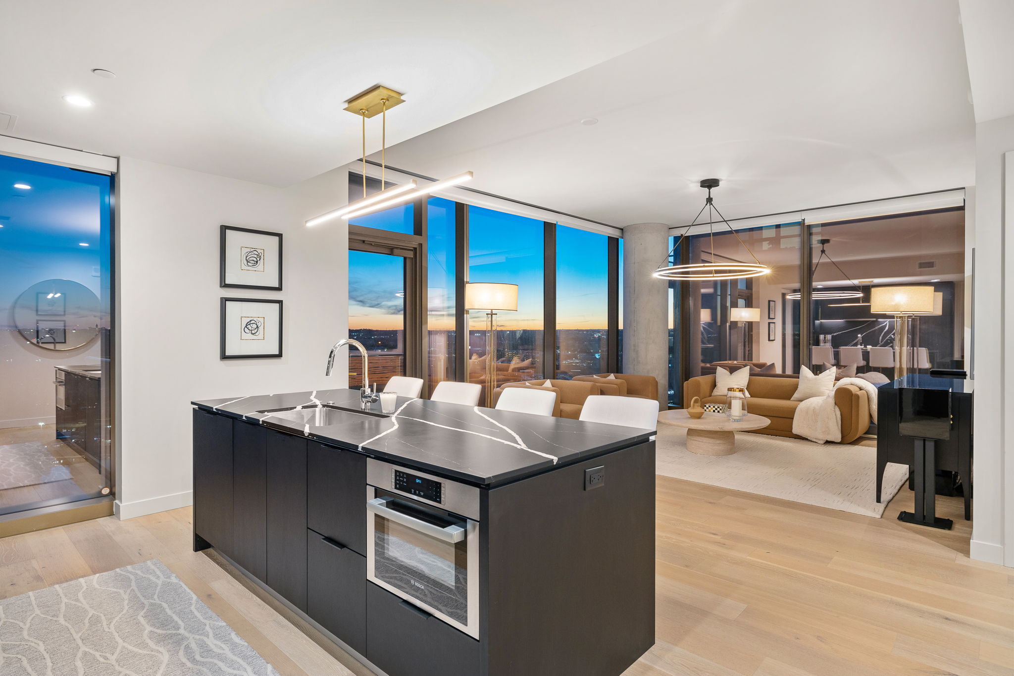 44 East Avenue, Unit 1801 Austin, TX 78701 - Photo 12 of 40 Kitchen featuring dark cabinetry, modern cabinets, hanging light fixtures, light wood-style flooring, and a kitchen island with sink