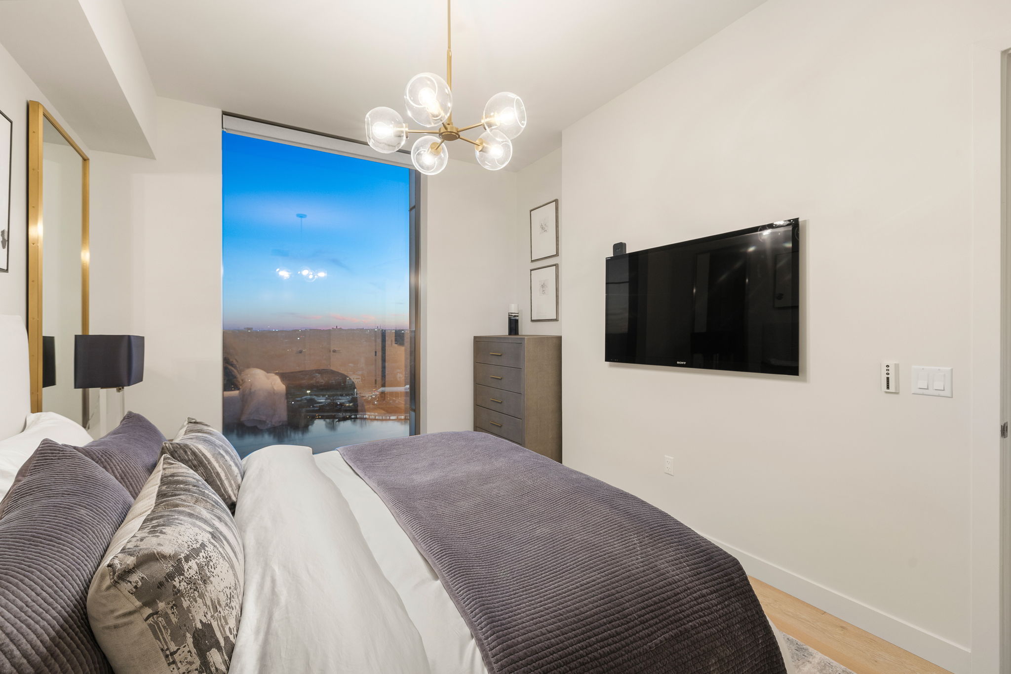 44 East Avenue, Unit 1801 Austin, TX 78701 - Photo 18 of 40 Bedroom featuring suspended lighting and wood finished floors