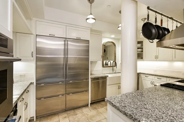 a kitchen with kitchen island stainless steel appliances a stove refrigerator and microwave