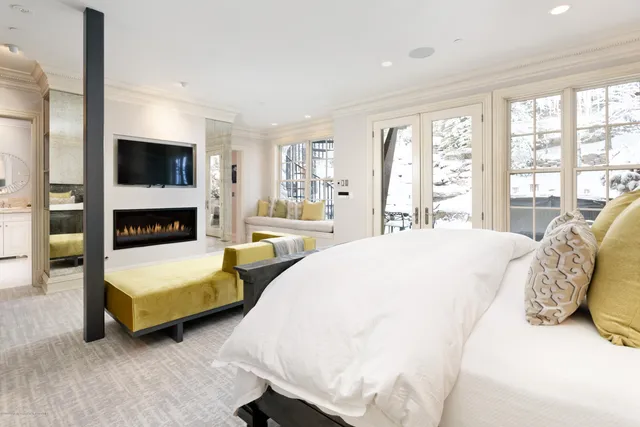 a spacious bedroom with a bed and a flat screen tv