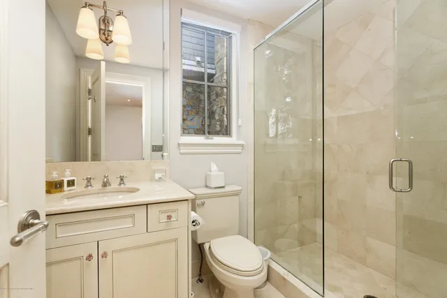 a bathroom with a sink toilet vanity and shower