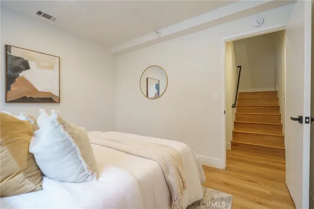 a bedroom with a bed and wooden floor