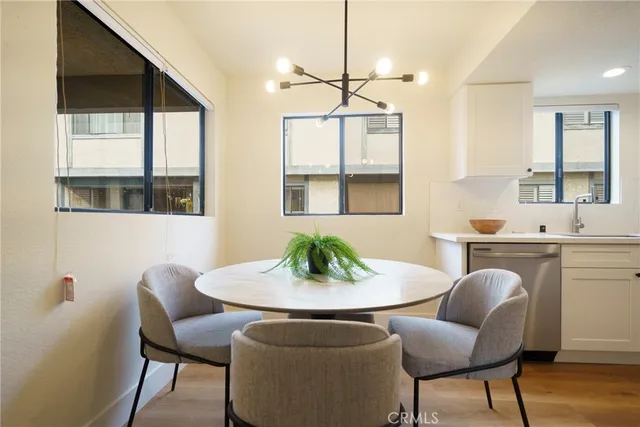 a dining room with furniture a chandelier and wooden floor