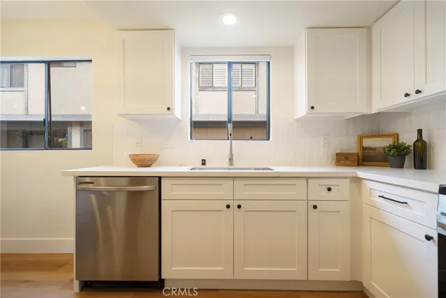 a kitchen with white cabinets and sink