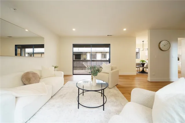 a living room with furniture a clock and a large window