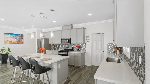 a kitchen with stainless steel appliances kitchen island granite countertop a refrigerator and a stove