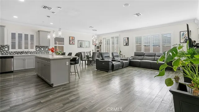 a living room with furniture kitchen view and a large window