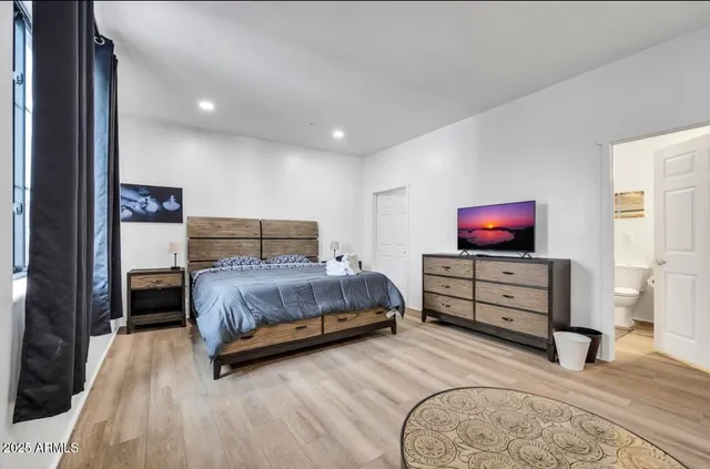 a bedroom with a bed and a flat screen tv