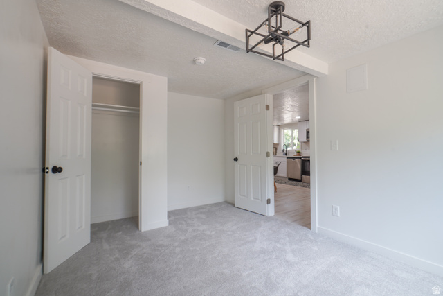557 Cook Street Ogden, UT 84404 - Photo 12 of 17 Neutral gray carpeting, white walls, and a contemporary black geometric flush mount light fixture