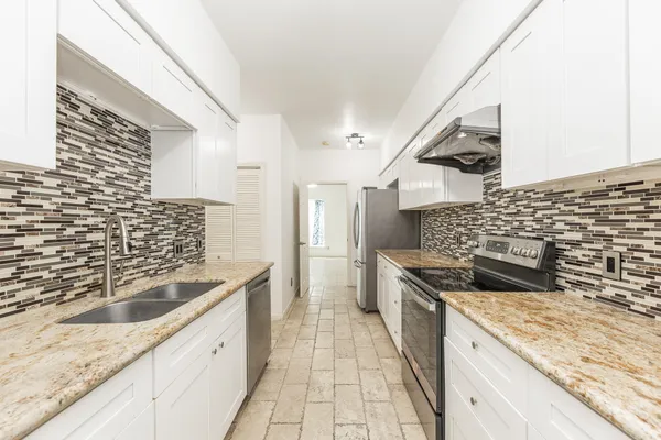 a kitchen with granite countertop a sink and a stove