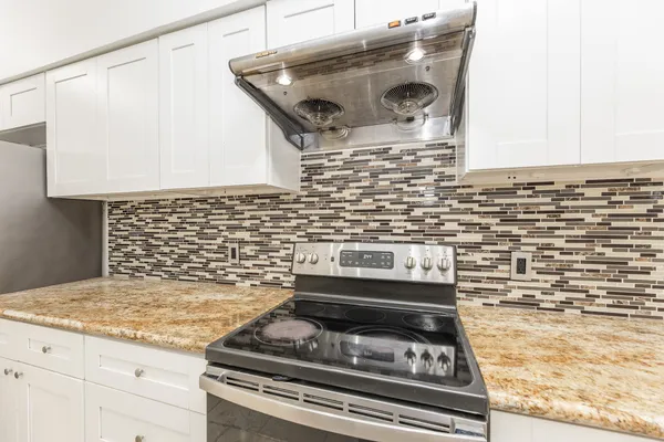 a stove top oven sitting inside of a kitchen