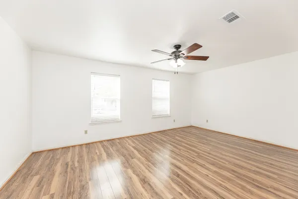 a view of a room with a window and a ceiling fan