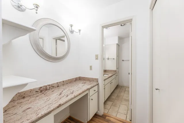 a bathroom with a granite countertop sink and a mirror